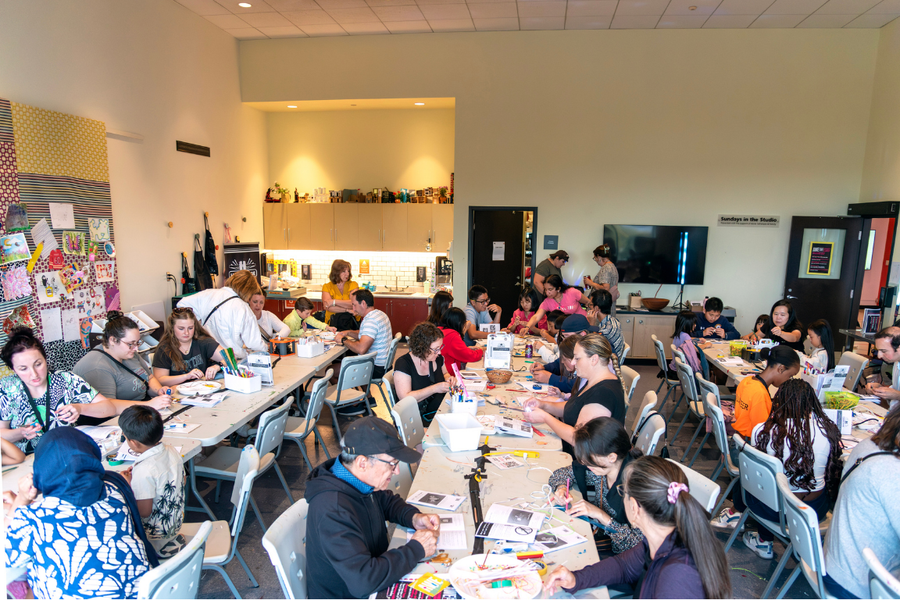 The Studio at Art Windsor Essex, packed with 3 rows of tables. People are working on their projects, focused but relaxed. Roughly 40 people are visible in the room.